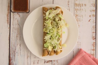 Geleneksel Meksika yemeği, kırmızı soslu altın etli taco (flauta)..