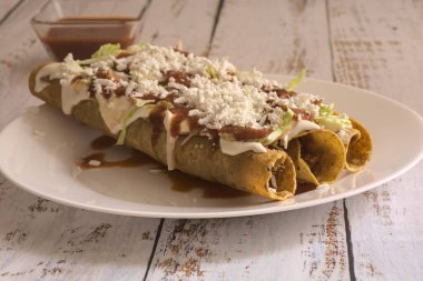 Geleneksel Meksika yemeği, kırmızı soslu altın etli taco (flauta)..