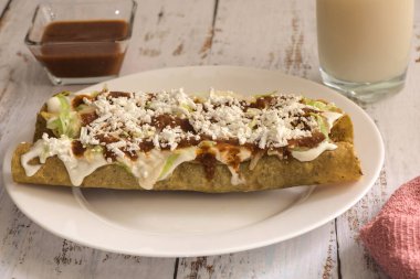 Geleneksel Meksika yemeği, kırmızı soslu altın etli taco (flauta)..