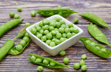 Taze bezelyeler (baklagiller), beyaz kabın içinde.