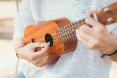 Genç kadın ukulele üzerinde oynama 