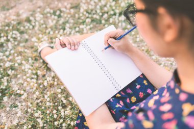 kadın beyaz çiçekli çayır günlüğüne yazma