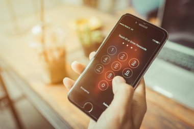 Onun perde şifre girmek için sayısal tuş takımı ile gösterilen bir elinde tutulan elma iphone6