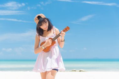 Ukulele plajda oynayan kadınlar. Asya kız Tayland Beach. Ukulele denizde oynayan güzel genç kadın 