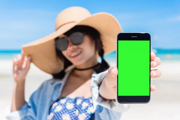 Piękna kobieta ręcznie przy użyciu inteligentnego telefonu na plaży. Ekranu smartfon zielony Beach z Tajlandii. — Zdjęcie stockowe
