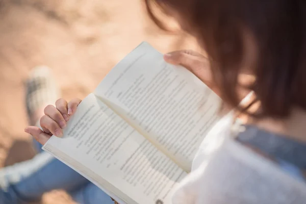 Bir kitap okuma genç bir kadın. Kadın elinde kitap