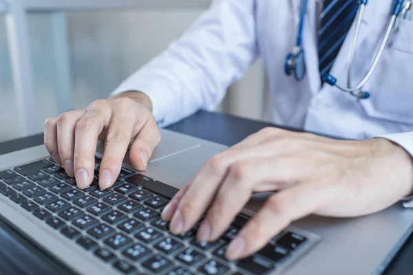 Primer plano de un trabajador médico escribiendo en el ordenador portátil —  Fotos de Stock