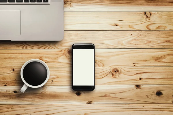 Ноутбук для смартфона та чашка кави на дереві — стокове фото