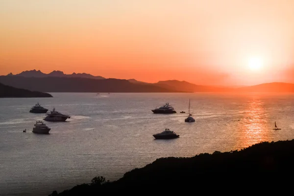 Boats in the calm sea at a pink sunset.Orange sky.Italy