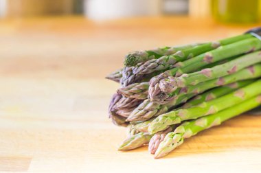 Tahtada bir sürü taze kuşkonmaz var.