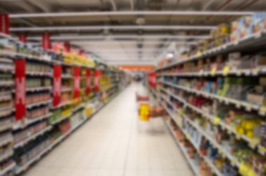 Renkli raflarla dolu soyut, bulanık süpermarket koridorunu görüntüle.