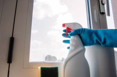 Pencereleri temizlemek için bir set. Mavi bir eldiven verin. Temizlik araçları ve ekipmanları.