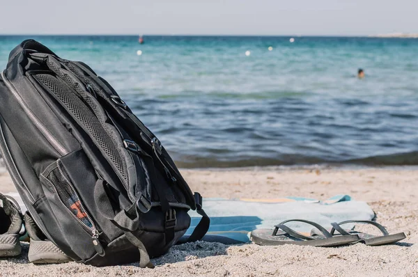 A Stylish black travelers backpack on the shore. The concept of travel, vacation, freedom.Copy place — Stock Photo, Image