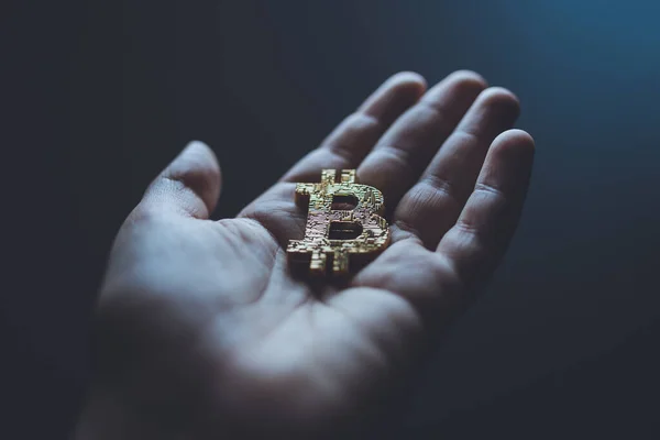 El ele tutuşan bitcoin logosu
