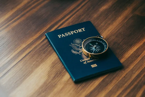 Mavi Amerikan pasaportunun üstüne bir altın pusula.