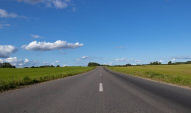 Boş asfalt bir yol ve mavi bir gökyüzü manzarası