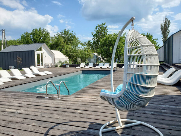 Очень красивый бассейн, отдых на свежем воздухе в жаркий летний день, красивый открытый бассейн и солнечные ванны без людей. Концепция летнего спорта и отдыха