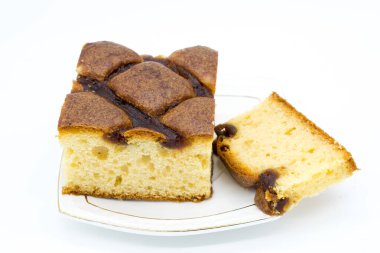 Beyaz arka planda beyaz bir tabakta reçelli şenlikli pasta.