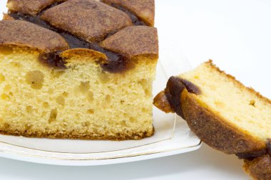 Beyaz arka planda beyaz bir tabakta reçelli şenlikli pasta.