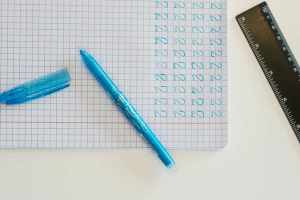İçinde numaralar olan bir defter görüntüsü, yanında bir kalem ve bir cetvel var.