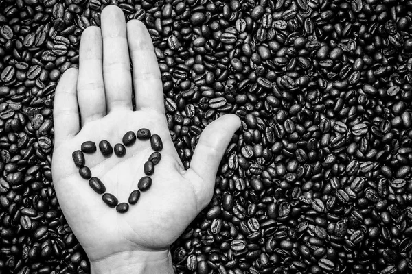 Coffee beans heart symbol on top of the hand — Stock Photo, Image