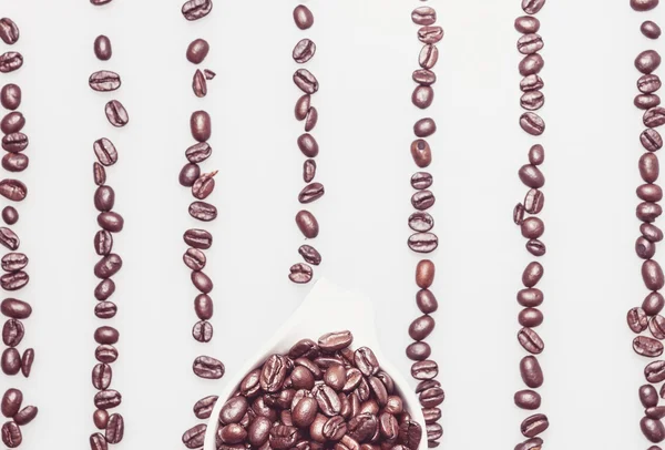 Coffee beans pattern with a coffee cup on top — Stock Photo, Image