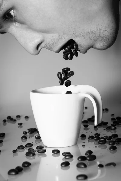 Coffee beans falling from person's mouth — Stock Photo, Image