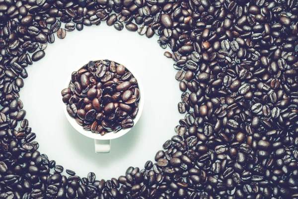 Textura de granos de café con una taza de café en círculo . — Foto de Stock