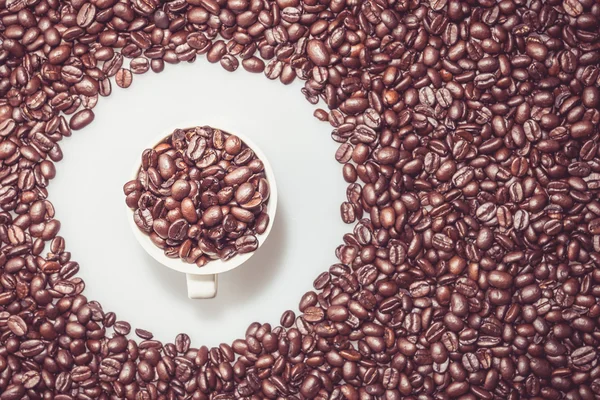 Coffee beans texture with a coffe cup in a circle. — Stock Photo, Image