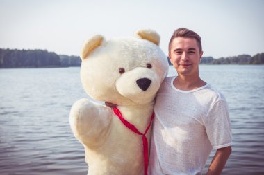 Adam büyük bir oyuncak ayı ile