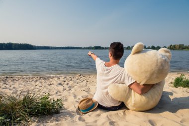 Adam büyük bir oyuncak ayı ile