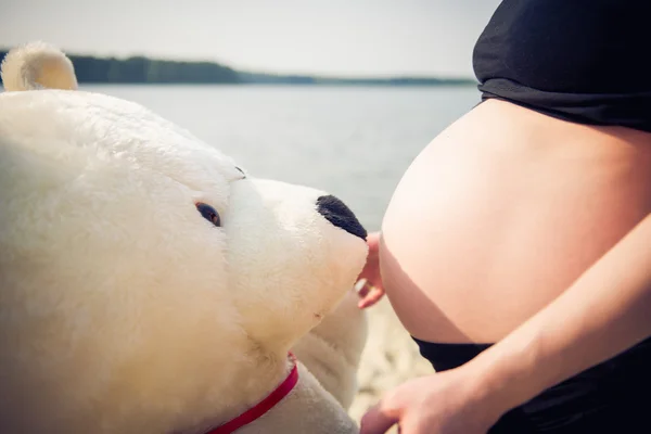 Mulher grávida bonita com um ursinho de pelúcia — Fotografia de Stock