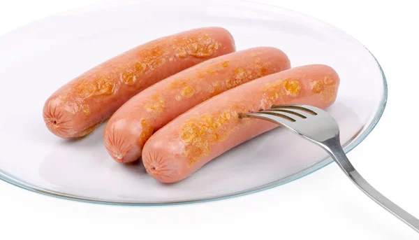 Trois délicieuses frankfurters sur une assiette blanche — Photo