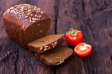 Çavdar ekmeği ayçiçeği tohumu ve eski bir tablo üzerinde domates