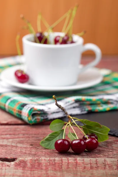 Cerezas en la copa sobre tabla de madera —  Fotos de Stock