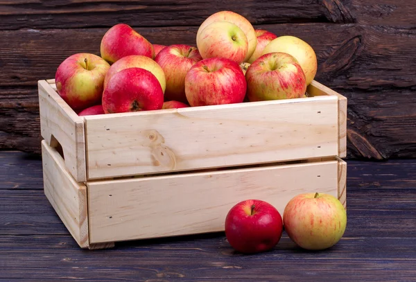 Wooden box full of fresh apples on a wooden background — Stock Photo, Image