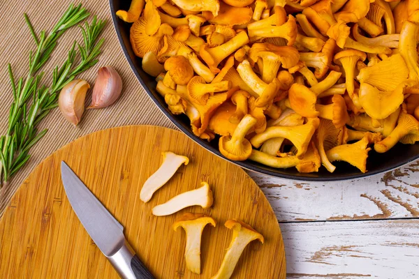 Chanterelles amarelo e faca em uma mesa de madeira — Fotografia de Stock