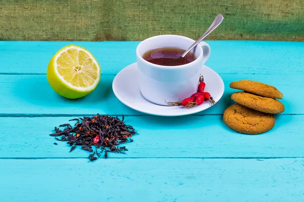 Black tea with a dogrose and oatmeal cookies — Stock Photo, Image