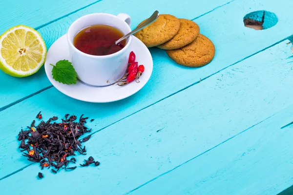 Black tea with a dogrose and oatmeal cookies — Stock Photo, Image