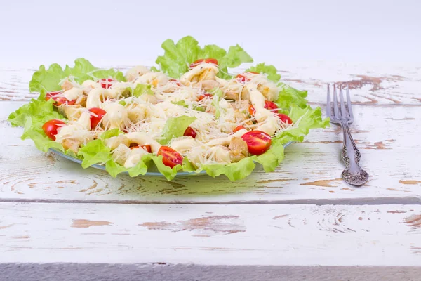 Caesar-Salat auf einem Servierteller auf einem Tisch — Stockfoto