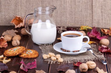 Kahve fincanı, krem, kahve taneleri ve yulaf ezmeli kurabiye