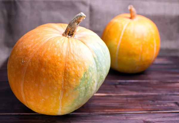 Twee grote pompoenen op een tafel — Stockfoto