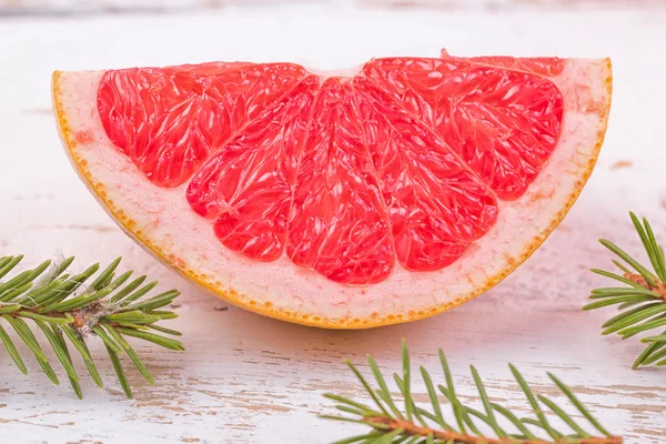 Segment of grapefruit and branch of a fir-tree — Stock Photo, Image