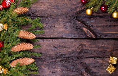 Çam kozalakları, küreler ve ahşap arka plan üzerinde çelenk