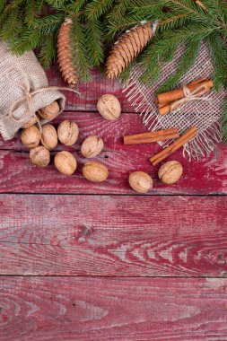 Ceviz, tarçın ve çam kozalakları ahşap arka plan üzerinde