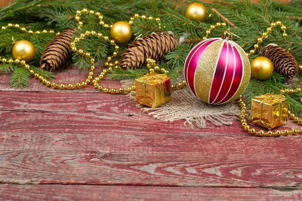 Adornos navideños y conos de abeto sobre un fondo de madera — Foto de Stock