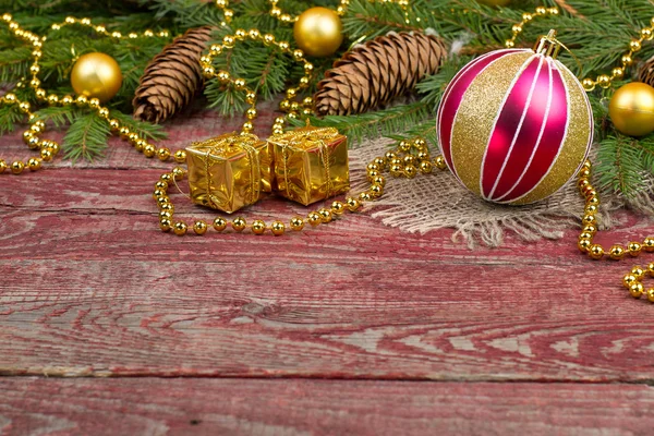 Adornos navideños y conos de abeto sobre un fondo de madera — Foto de Stock
