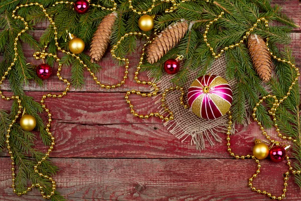 Adornos navideños y conos de abeto sobre un fondo de madera — Foto de Stock