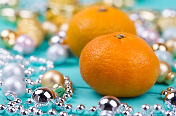 Tangerines and baubles on a table — Stock Photo, Image