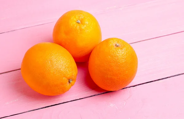 Oranges on a pink table — Stock Photo, Image